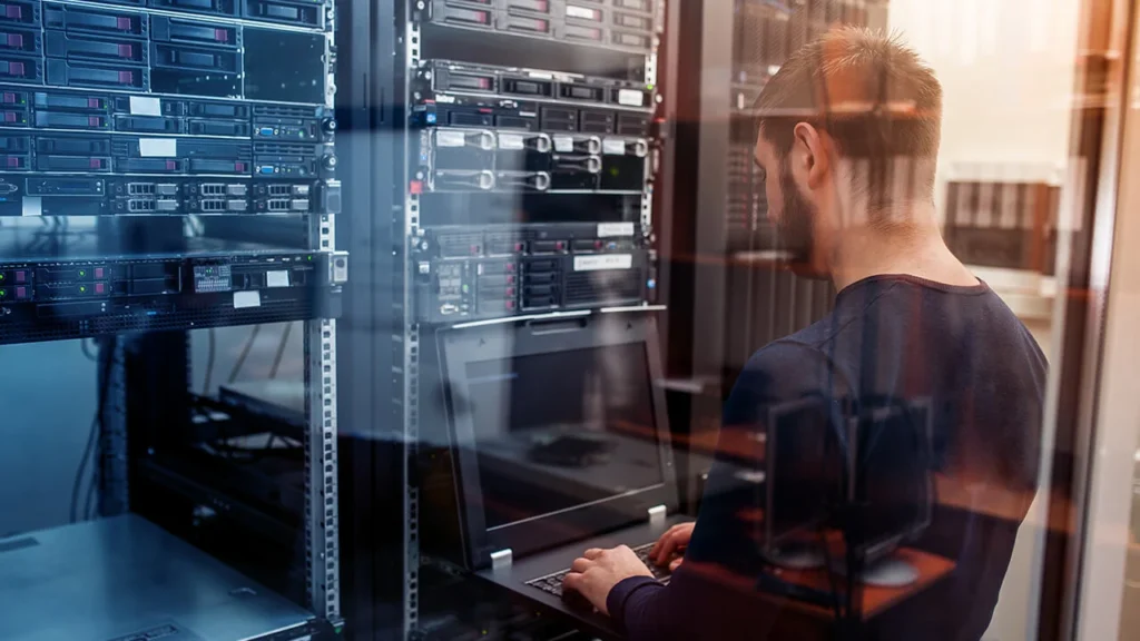 IT technician managing server equipment in a data center room.
