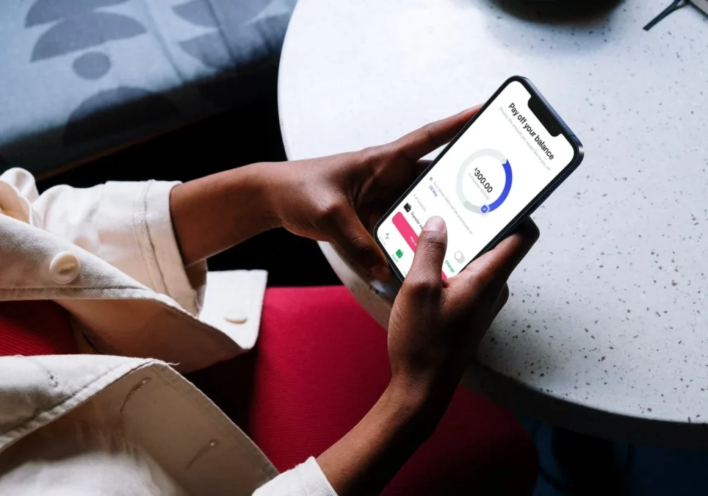 Person using mobile phone app with data progress and finance tracker.